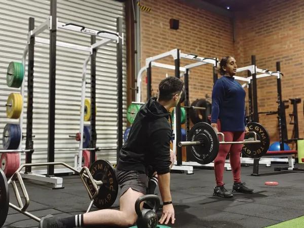 A coach working with members on the gym floor